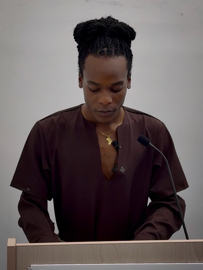 Deyner Caicedo Camacho reading from his notes at a lectern