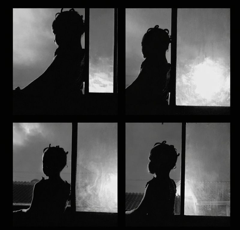 Four black-and-white photographs of a girl in silhouette with braided hair, looking out of a window